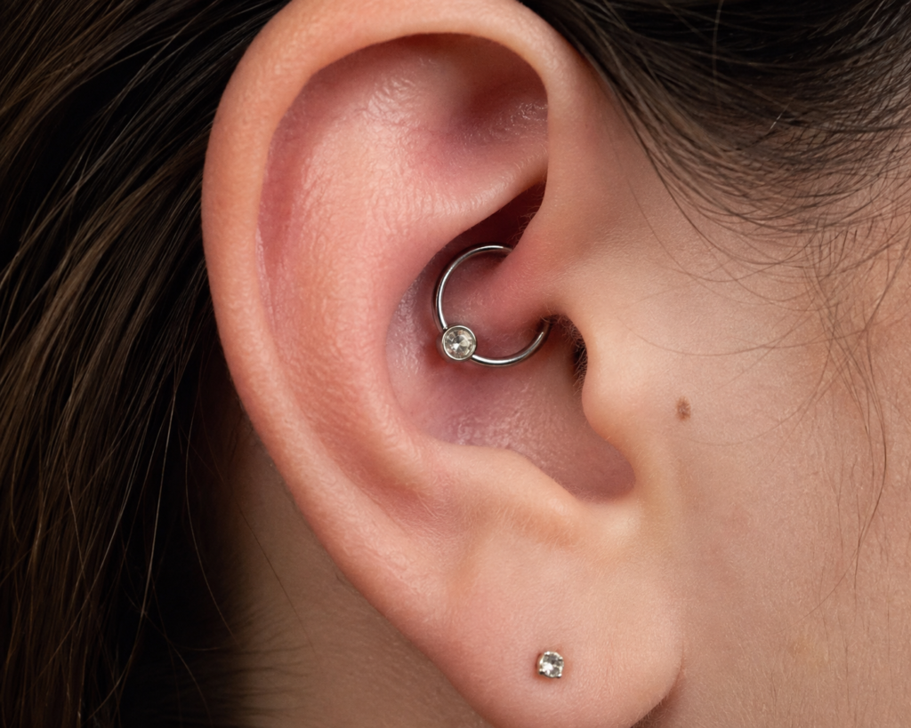 Close-up of a daith ear piercing with a silver captive bead ring